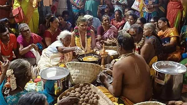 An elderly woman bakes bread in boiling ghee with her hands. People gathered to witness the special event!